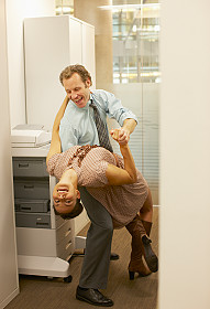 Man and woman dancing in the copier room